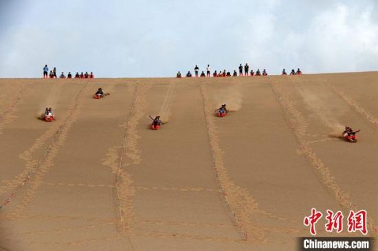 6月13日，敦煌鳴沙山月牙泉景區(qū)舉辦滑沙比賽。　張曉亮 攝