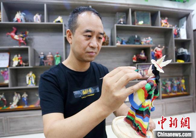 圖為安秋平正在創(chuàng)作代表隴南文縣民俗的《白馬人》作品?！「哒?攝