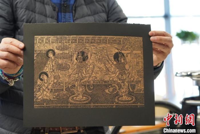 圖為手工書藝人展示敦煌雕版壁畫印刷品?！【琶赖┰?　攝