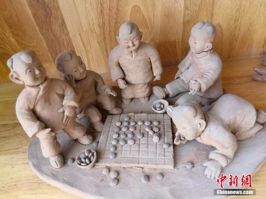 圖為泥塑作品展現(xiàn)下棋場景。 劉玉桃 攝