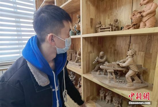 圖為學(xué)生欣賞泥塑作品。 劉玉桃 攝