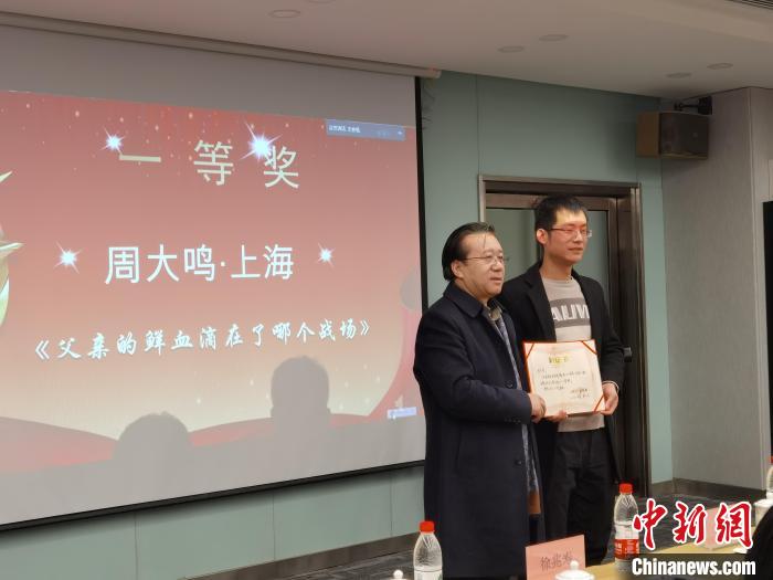 圖為作家、西北師范大學(xué)新聞與傳媒學(xué)院院長徐兆壽頒發(fā)一等獎(jiǎng)證書，代領(lǐng)獎(jiǎng)?wù)呱吓_(tái)領(lǐng)獎(jiǎng)?！钅?攝