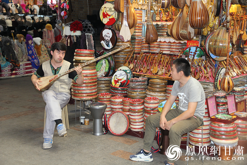 烏魯木齊二道橋巴扎內(nèi)，店主正在向客人展示樂(lè)器。楊文遠(yuǎn) 攝