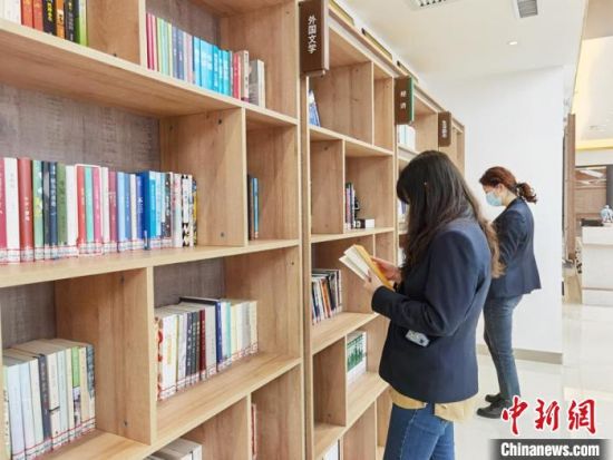 圖為在甘肅公航旅建設(shè)集團有限公司的職工書屋，職工挑選書籍?！⌒煅?攝