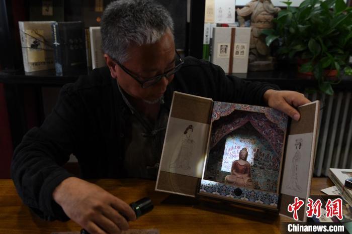 圖為讀者出版集團(tuán)讀者晉林工作室獨立出品人徐晉林，展示互動性強(qiáng)的敦煌題材手工書。(資料圖) 楊艷敏 攝