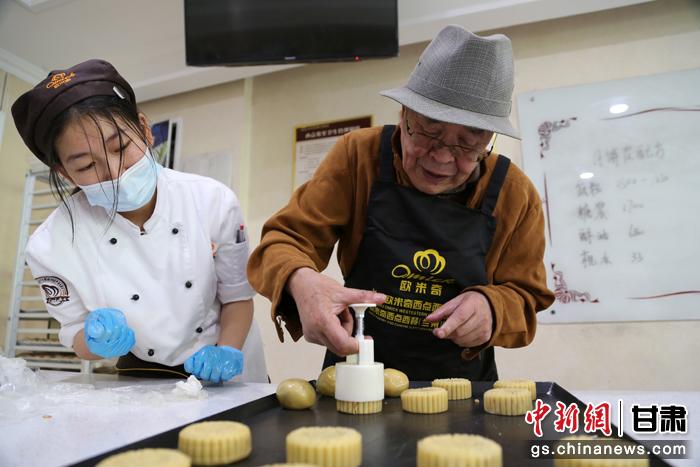 當(dāng)日，受邀參加活動(dòng)的臺(tái)胞臺(tái)屬代表、兩岸婚姻及子女、在甘臺(tái)商代表等歡聚一堂。圖為77歲的在甘臺(tái)胞潘天鑒制作月餅。九美旦增 攝