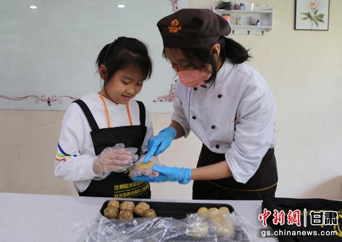 圖為在甘臺(tái)胞小朋友在工作人員指導(dǎo)下制作月餅。九美旦增 攝