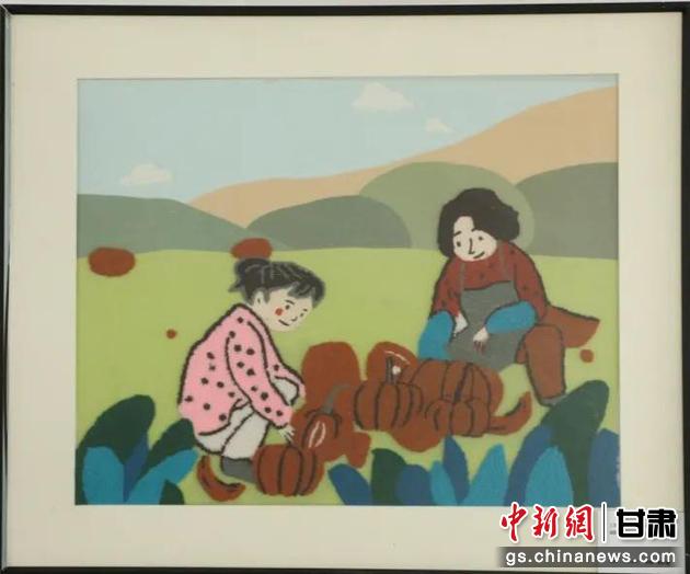 嘉峪關(guān)市新城鎮(zhèn)新城村農(nóng)業(yè)產(chǎn)業(yè)園區(qū)內(nèi)，母女兩人在摘南瓜。刺繡 馬艾米乃 繡稿 敬紅霞