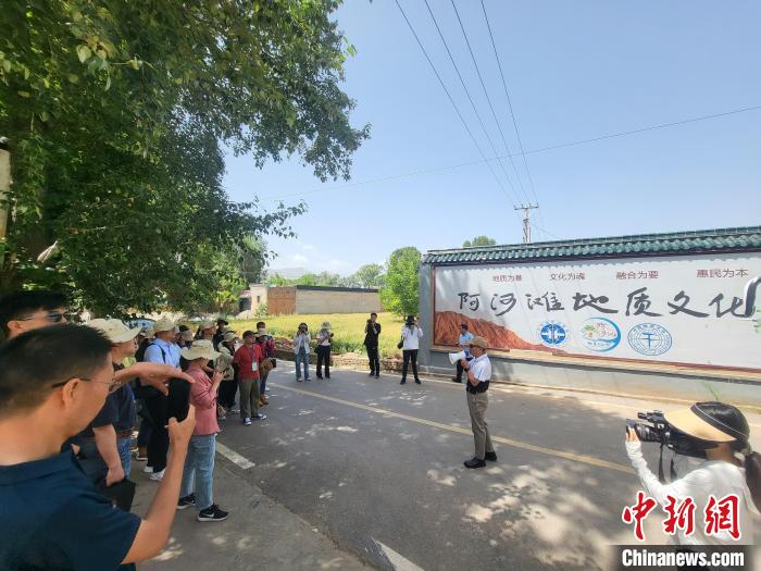 圖為中國地質(zhì)大學(xué)(北京)教授張緒教介紹村落情況?！『衍?攝