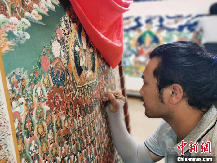 圖為更登才讓的徒弟繪畫唐卡。　張?zhí)砀?攝