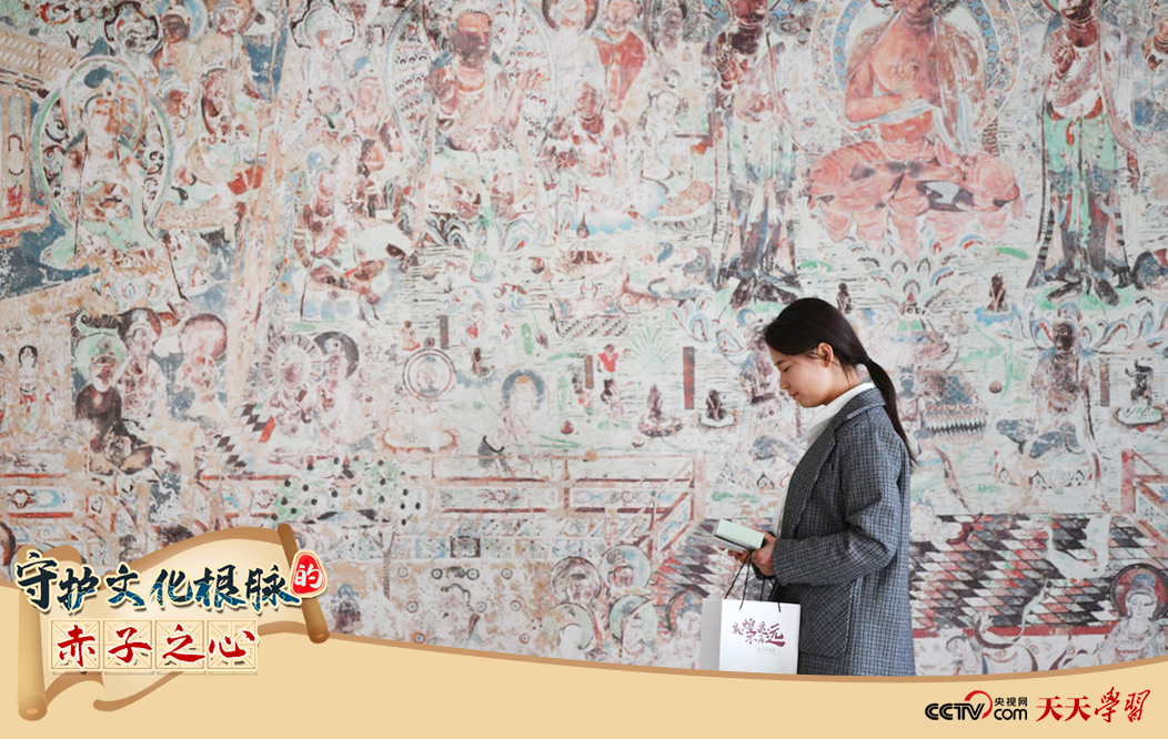 2023年4月25日，敦煌研究院文物數(shù)字化保護(hù)團(tuán)隊(duì)創(chuàng)意營銷人員廖雪婷從一幅高保真復(fù)制壁畫前走過。