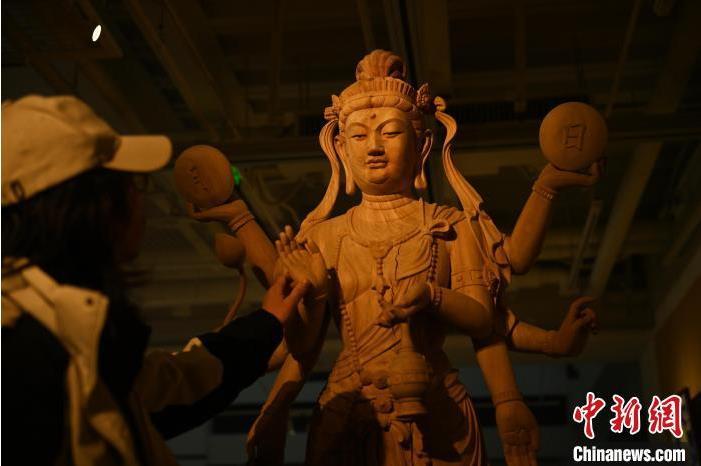 圖為季茂杰觀察自己創(chuàng)作的敦煌木雕。李亞龍 攝</p>
<p>