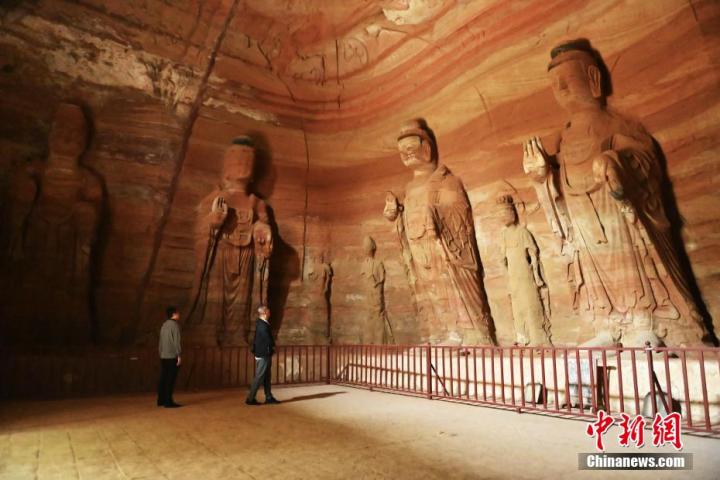 7月15日，游人參觀甘肅省平?jīng)鍪袥艽h百里石窟長廊中的南石窟寺1號窟。百里石窟長廊位于涇川縣境內(nèi)，由512個石窟、5眼窟中石井組成，現(xiàn)存王母宮石窟、鳳凰山石窟、南石窟寺、丈八寺石窟、羅漢洞石窟、太山寺石窟等規(guī)模較大的石窟群，還有數(shù)量眾多的小石窟群。南石窟寺開鑿于北魏永平三年，其中1號窟屬于大型七佛窟，七佛高達6米。中新社記者 李亞龍 攝